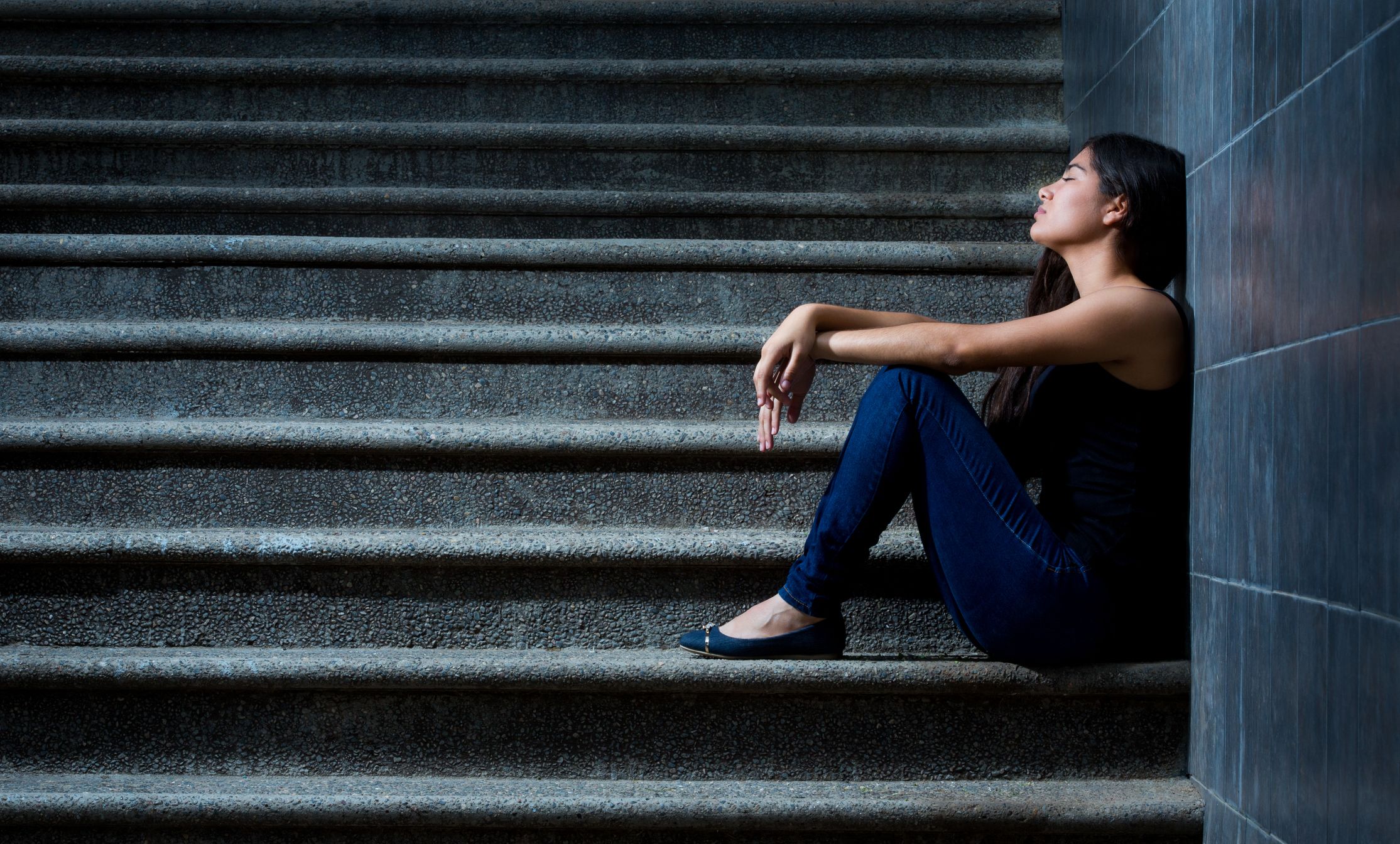 Woman sitting on a staircase, melancholic